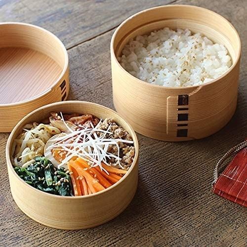 Houten bento met rijst en kleurrijke groenten op tafel